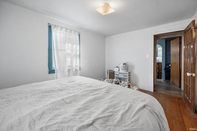 bedroom featuring radiator heating unit and wood finished floors