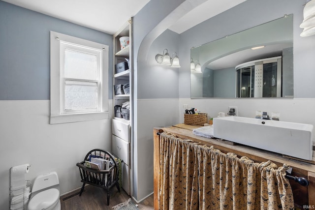 bathroom featuring a shower stall, vanity, and wood finished floors