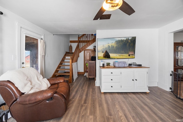 living room with stairway, radiator heating unit, visible vents, and dark wood-style flooring