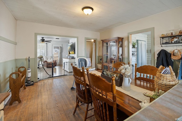 dining area featuring hardwood / wood-style flooring and a wainscoted wall