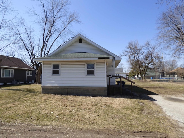 view of side of home featuring a trampoline and a lawn