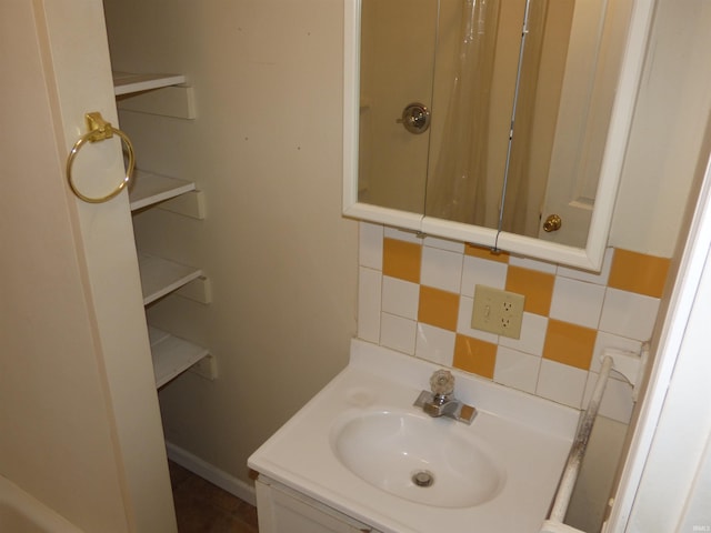 bathroom featuring decorative backsplash, vanity, and baseboards