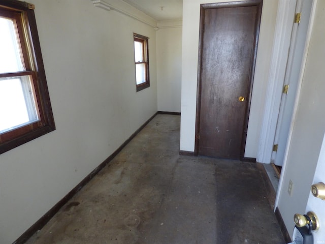 unfurnished bedroom featuring a closet, baseboards, and concrete flooring