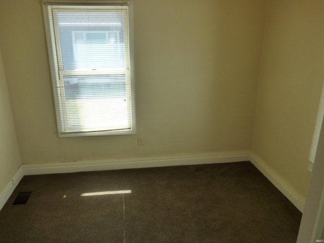 empty room featuring carpet, visible vents, and baseboards