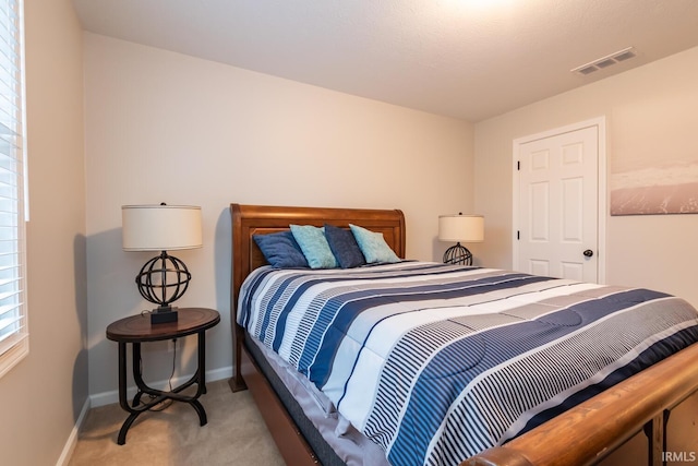 carpeted bedroom with visible vents and baseboards