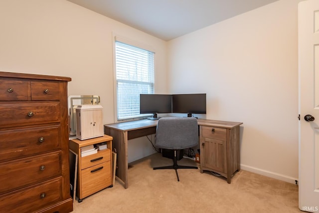 office area featuring light carpet and baseboards