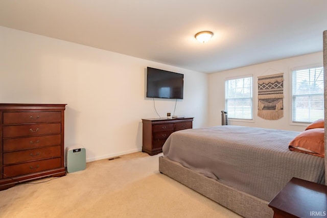 bedroom featuring light carpet, visible vents, and baseboards