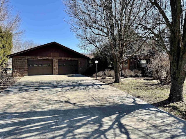 view of front of home featuring brick siding, concrete driveway, and a garage