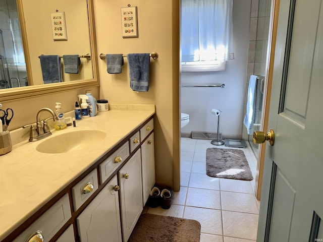 bathroom featuring tile patterned flooring, toilet, vanity, and a shower with door