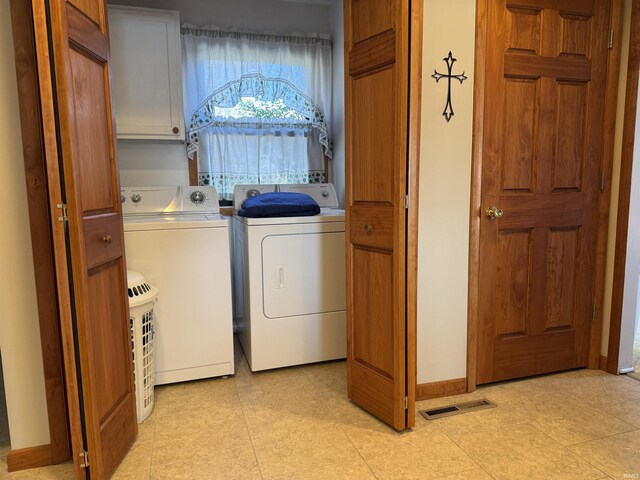 clothes washing area featuring cabinet space, visible vents, independent washer and dryer, and baseboards