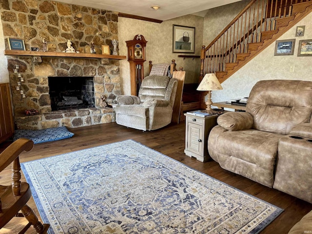 living area with a stone fireplace, stairway, and hardwood / wood-style floors