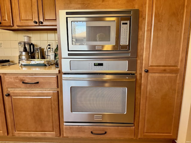 kitchen with light countertops, brown cabinetry, tasteful backsplash, and stainless steel appliances