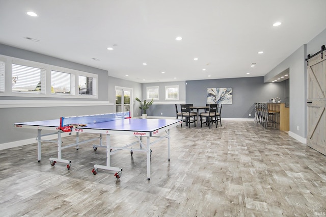 playroom featuring wood finished floors, baseboards, visible vents, recessed lighting, and a barn door