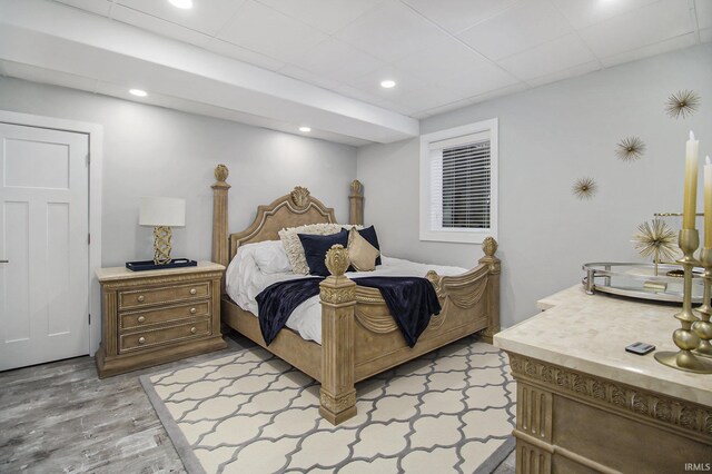 bedroom with recessed lighting, a paneled ceiling, and light wood finished floors