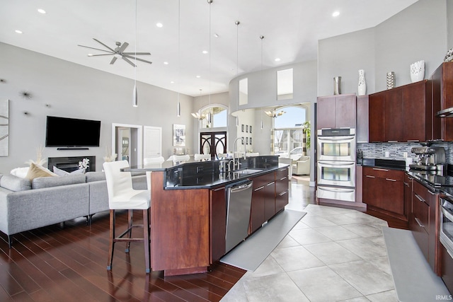 kitchen with a sink, stainless steel appliances, a kitchen bar, and open floor plan