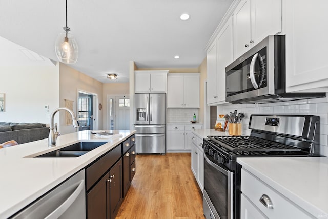 kitchen with stainless steel appliances, light countertops, and a sink