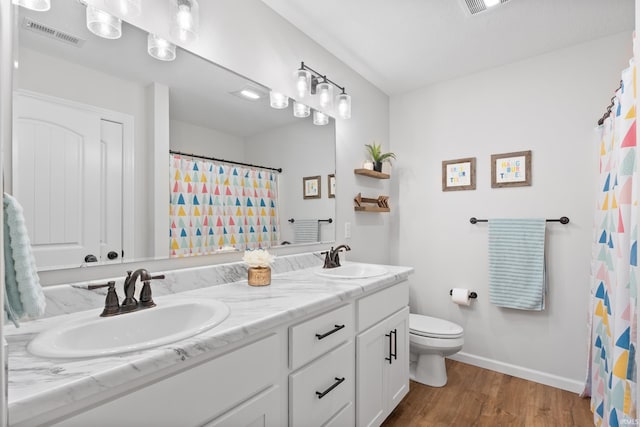 full bathroom with toilet, wood finished floors, visible vents, and a sink