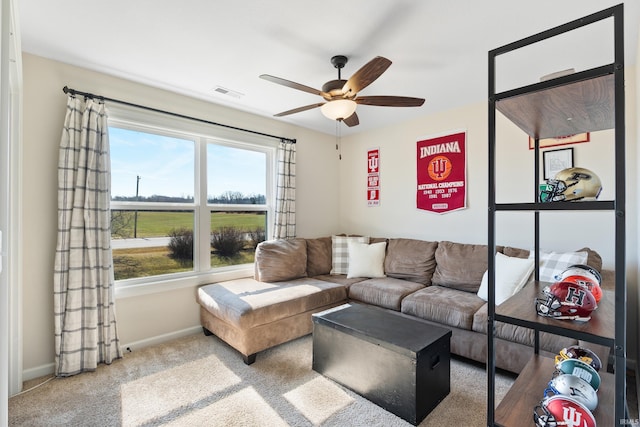 living room featuring ceiling fan, carpet, visible vents, and baseboards