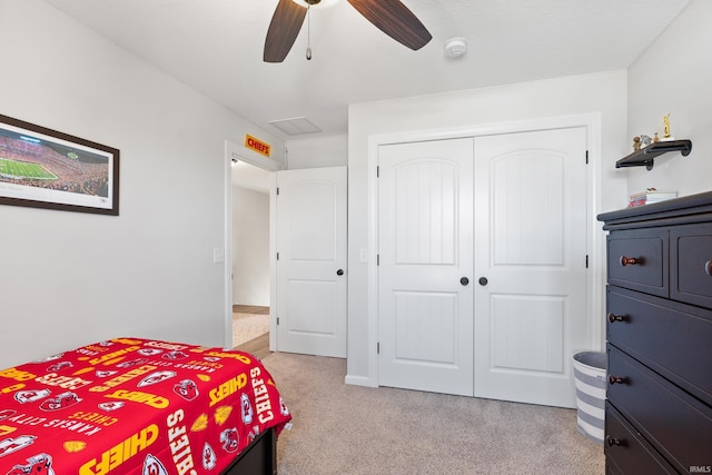 bedroom with a closet, light carpet, and ceiling fan