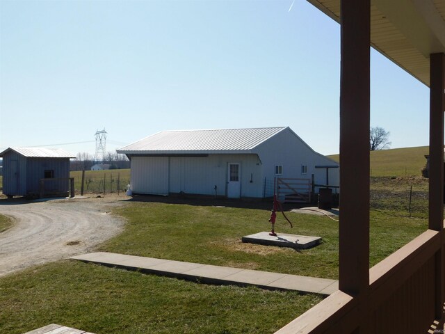 view of yard with driveway, an outdoor structure, and fence