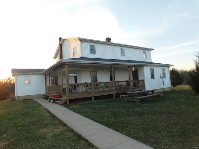 back of house with a lawn and a chimney