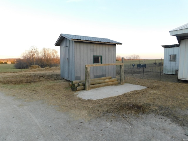 view of shed featuring a rural view and fence