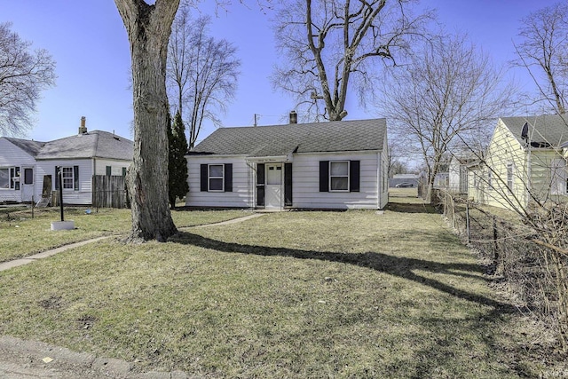 bungalow featuring a shingled roof, a front lawn, and fence