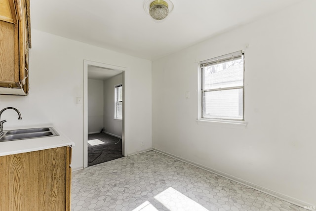 interior space with a sink, baseboards, and tile patterned floors