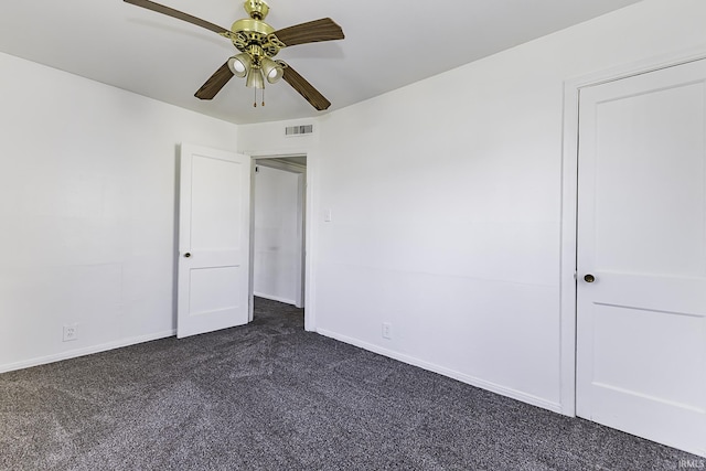 unfurnished bedroom with visible vents, dark carpet, a ceiling fan, and baseboards