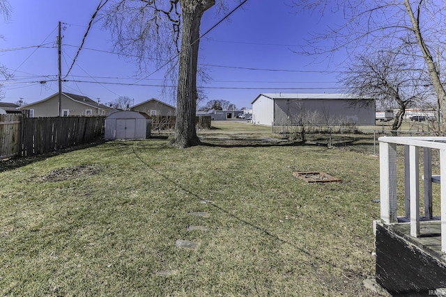 view of yard featuring an outbuilding, fence, and a shed