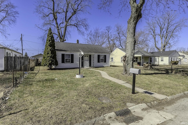 view of front of home with a front yard and fence