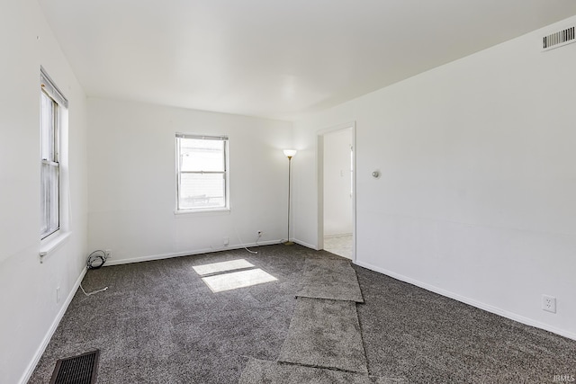 empty room featuring visible vents, carpet floors, and baseboards