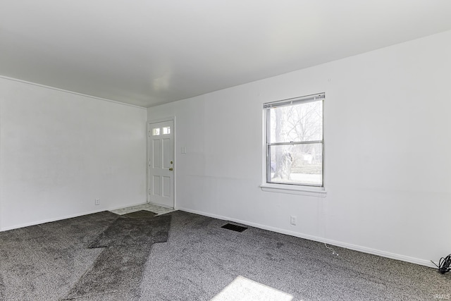 carpeted spare room with baseboards and visible vents