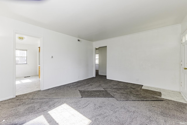 carpeted spare room with visible vents and baseboards