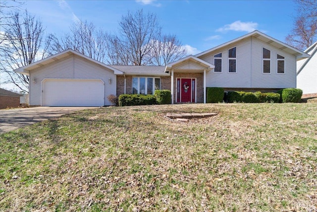 tri-level home featuring a garage, a front yard, brick siding, and driveway