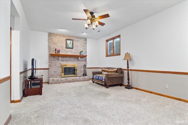 living area with baseboards, carpet, a brick fireplace, and ceiling fan