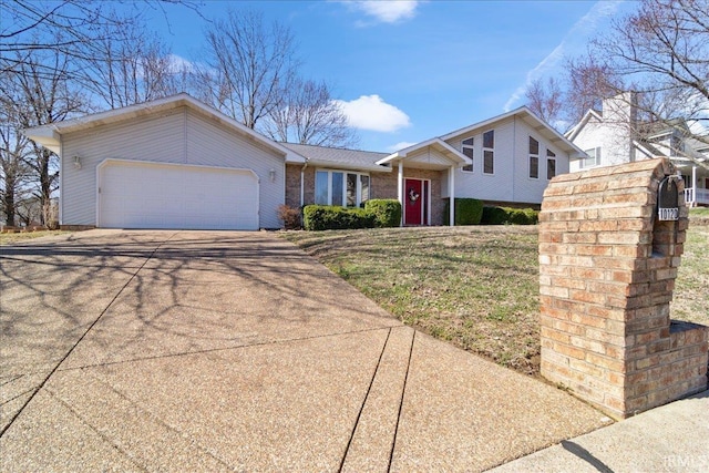 tri-level home with a garage, brick siding, and concrete driveway