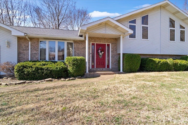 view of front of house with brick siding and a front lawn