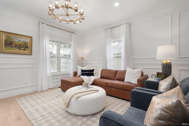 living room featuring crown molding, a decorative wall, and a wealth of natural light