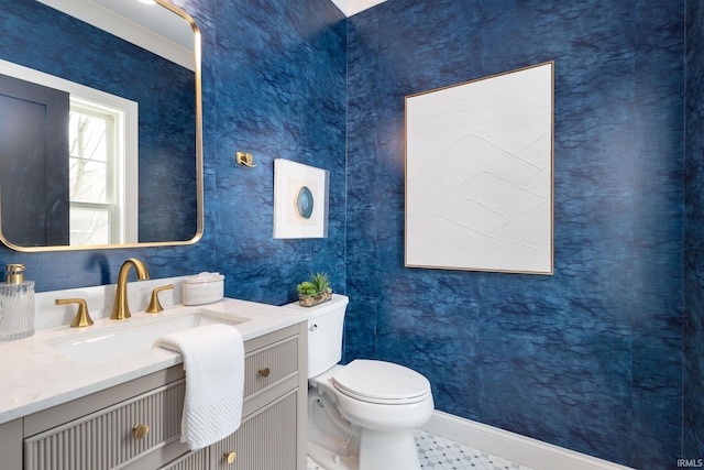 bathroom featuring vanity, toilet, and baseboards