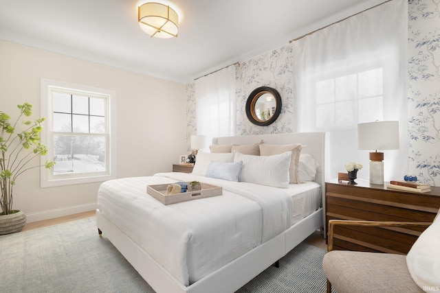 bedroom featuring wallpapered walls, wood finished floors, and baseboards