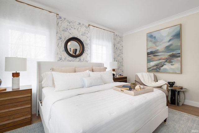 bedroom with crown molding, baseboards, and wood finished floors