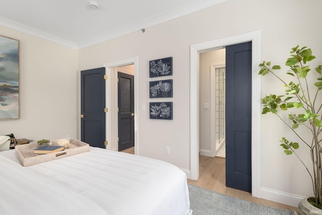 bedroom with crown molding, light wood-style flooring, and baseboards