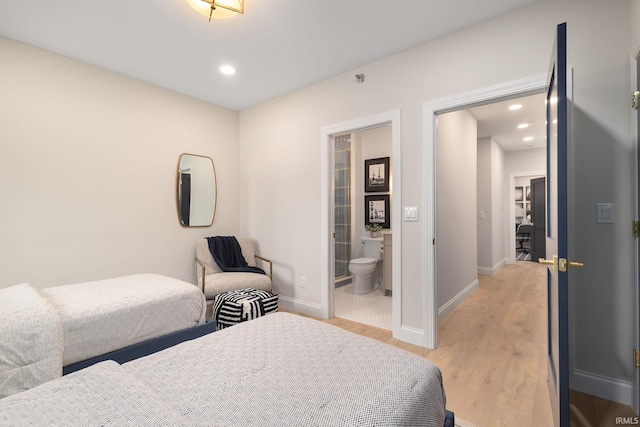 bedroom with recessed lighting, connected bathroom, baseboards, and light wood-style floors