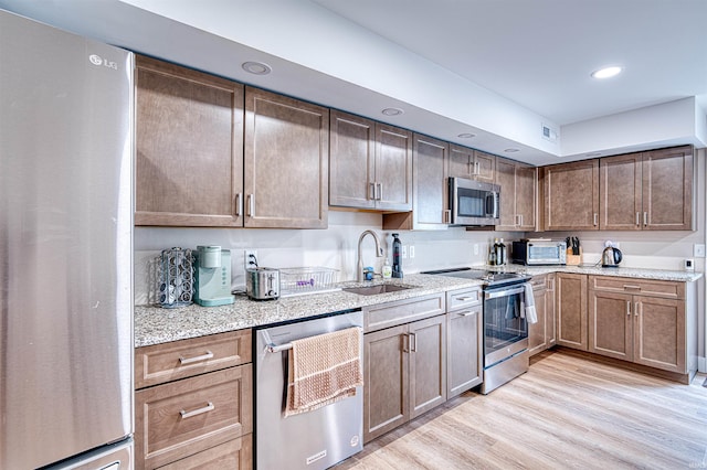 kitchen featuring visible vents, recessed lighting, a sink, stainless steel appliances, and light wood-style floors