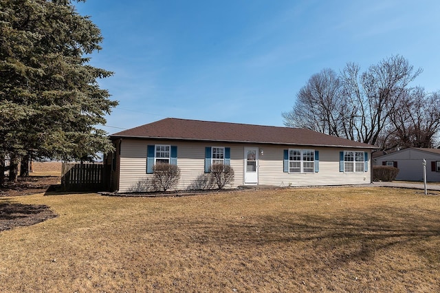 ranch-style house with a front yard and fence