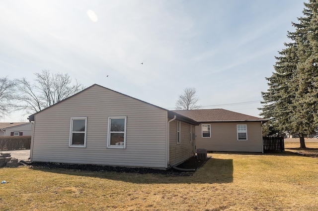 back of house with a lawn and central AC