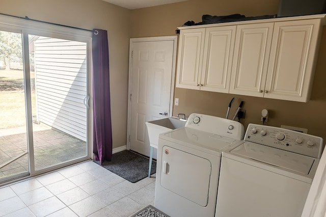 clothes washing area with light tile patterned floors, cabinet space, baseboards, and washer and clothes dryer