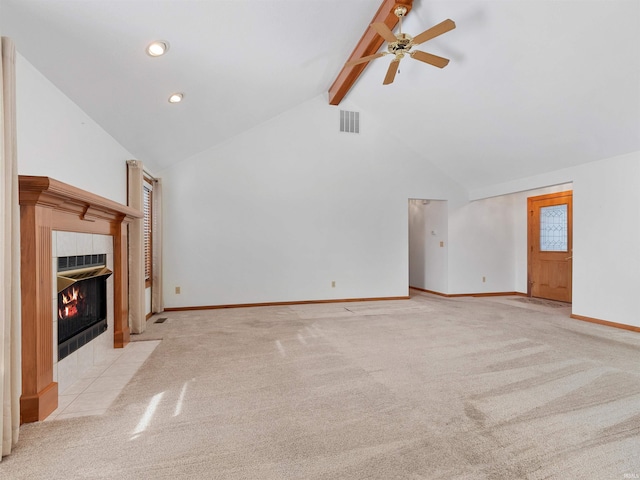 unfurnished living room with visible vents, beam ceiling, carpet floors, and a tile fireplace