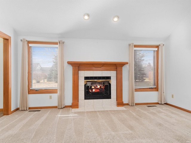 unfurnished living room featuring a fireplace, visible vents, carpet floors, and baseboards